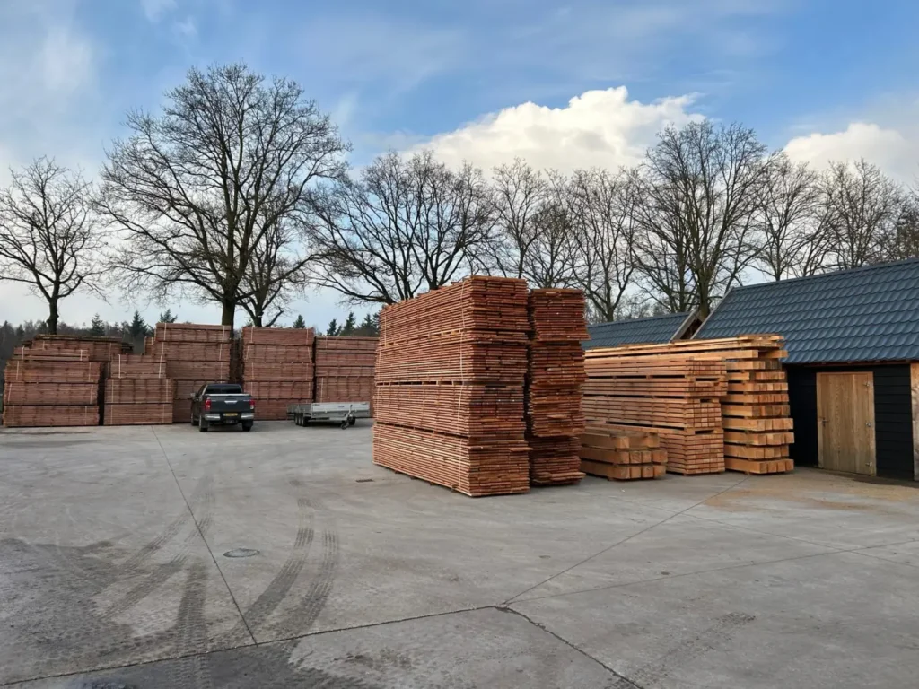 Het buitenterrein van CenWood met stapels douglas planken en balken onder een blauwe lucht