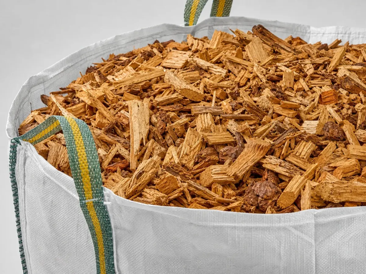 Close-up van een big bag met grove houtchips in warme goudbruine tinten