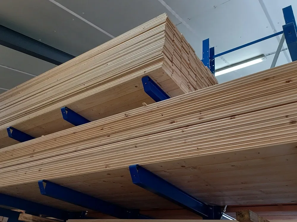 Douglas planken op blauwe draagarmstellingen in het magazijn, van onderaf gezien