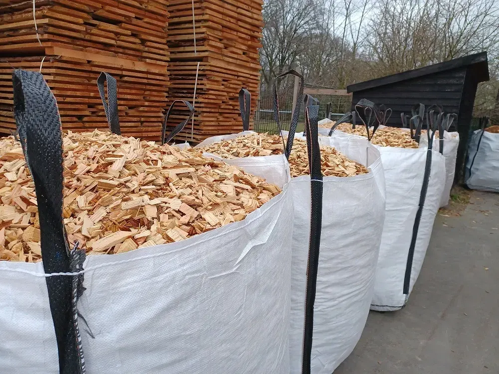 Rij big bags gevuld met houtsnippers op het terrein van de houthandel