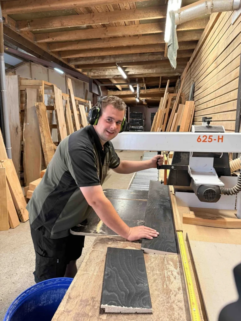 Medewerker van CenWood schaaft een plank op maat in de werkplaats voor houtmaatwerk